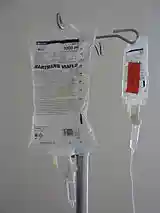 Photograph of two intravenous solution bags hanging from a pole.