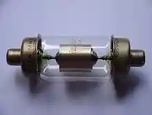 A glass cylinder capped on both ends with metal electrodes. Inside the glass bulb there is a metal cylinder connected to the electrodes.