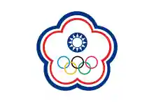 A white symbol in shape of a five petal flower ringed by a blue and a red line. In its centre stands a circular symbol depicting a white sun on a blue background. The five Olympic circles (blue, yellow, black, green and red) stand below it.