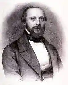 Photo of the upper body of a bespectacled man