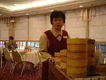 A server pushes a cart laden with bamboo baskets