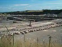 Large expanse of exposed grey rock. Fence in the foreground.