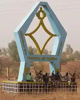 Children sit under the monument to the Festival of Tahoua