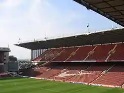 A grandstand at a sports stadium. The seats are predominantly red.