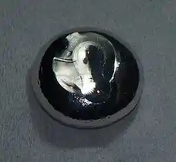 A flattened drop of dark gray substance