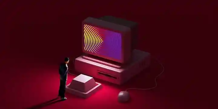 Una persona in miniatura che osserva un enorme tasto di una tastiera e lo schermo di un computer ipnotico